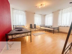 a room with two beds and two chairs in it at MonteurWohnung Wilsdruff App 2 in Wilsdruff