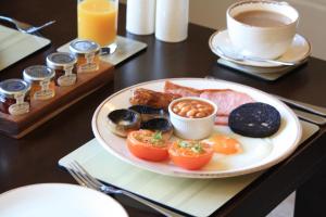 a plate of donuts on a table with a cup of coffee at The Rectory Lacock - Boutique Bed and Breakfast in Lacock