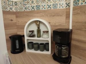a room with a coffee maker and a coffeemaker at Gîte Bienvenue chez Naty in Audrieu
