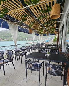 a restaurant with tables and chairs and a view of the water at Hotel Royal Drina in Mali Zvornik