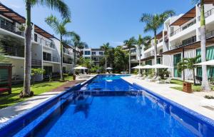 an image of a swimming pool at a resort at Luxurious & Central Condo In Playa Steps From The Beach in Playa del Carmen