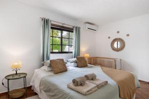 une chambre avec un grand lit avec des serviettes dessus dans l'établissement Casa Lavadeira - Vinhas De Nexe, à Faro