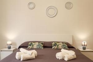 a bedroom with a bed with white towels on it at Don Camillo Maison in Avola