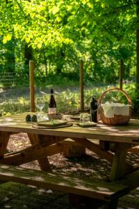 a picnic table with two bottles of wine and a basket at Tiny House - Gilda e i suoi amici in Neive +6 photos