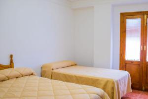 Un dormitorio con dos camas y una ventana. en Apartamento Oran 2, en Castril