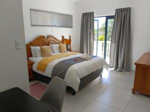 una camera da letto con un letto, una scrivania e una finestra di Large Suite - Dream Den at Rustic Dune 3 a Jeffreys Bay