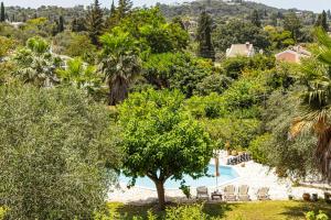 a view of a resort with a pool and trees at Mouse House in Gouvia