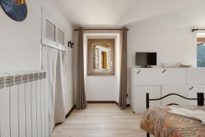 Un dormitorio blanco con una cama y una ventana. en Il Giostro 2 Biassa, en La Spezia