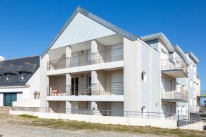 an apartment building with balconies on the side at Rêve Bleu, 2 p, vue mer panoramique in Penmarcʼh