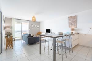 a kitchen and living room with a table and chairs at Rêve Bleu, 2 p, vue mer panoramique in Penmarcʼh