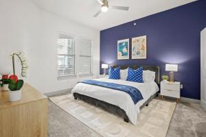 a bedroom with a large bed with a blue wall at Stylish 2BR Apartment, Near Galleria Dallas, Free Parking, Gym & Pool in Dallas