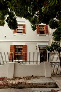 a white house with brown windows and a fence at Double Story at 55 in Graaff-Reinet