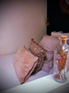 a vase sitting on top of a bed with pillows at L'Arôme - Studio intimiste à deux pas du tram et des facultés in Talence +8 photos
