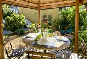 une table avec des assiettes et des fleurs sur une terrasse dans l'établissement Casa Nora, à Castiglioncello