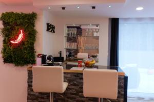 a restaurant with a bar with white chairs at Loveroom de charme avec jacuzzi et sauna in La Penne-sur-Huveaune