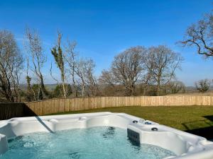 a hot tub in a yard with a fence at Brockview House - Eco 4 bed in Holcombe +38 photos