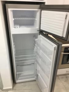 an empty refrigerator with its door open in a kitchen at Mediterranean Apartments 1 in Paphos City