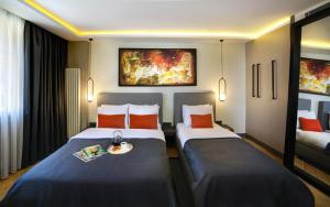 a hotel room with two beds and a tray of food at The Capital Hotel in Istanbul