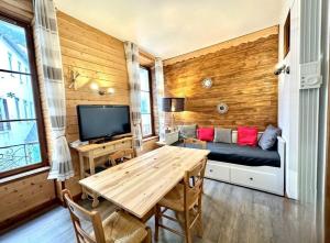 una sala de estar con un sofá y una mesa en Appartement 4 à 6 personnes Hyper Centre au Calme dans impasse AVEC PARKING, en Cauterets 21 fotos más