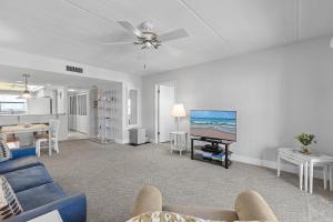 Una sala de estar con un sofá azul y un televisor de pantalla plana. en Ocean Terrace Club 706, en Daytona Beach Shores