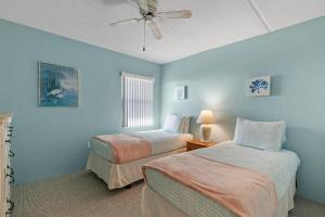Dos camas en una habitación con paredes azules. en Ocean Terrace Club 706, en Daytona Beach Shores 60 fotos más