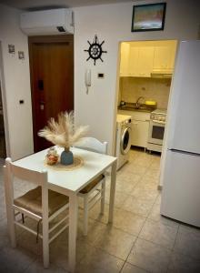 a kitchen with a white table and chairs and a sink at Casa Gioia in Chioggia