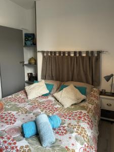 a bed with pillows on it in a bedroom at le Cozy Bayeusain in Bayeux