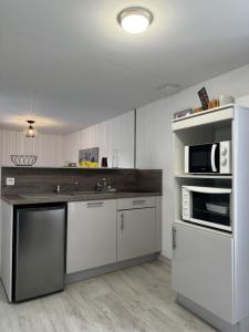 a kitchen with white cabinets and stainless steel appliances at le Cozy Bayeusain in Bayeux