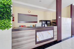 デンパサールにあるCollection O Near Bali Royal Hospital Renon Formerly JC Boutique Hotelの大型スクリーンを備えた受付デスクのあるオフィス