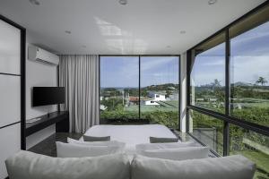 a living room with a couch and a large window at Villa Onyx in Amphoe Koh Samui