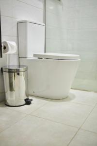 a bathroom with a toilet and a trash can at Coast to Coast Homes in Gwarinpa +51 photos