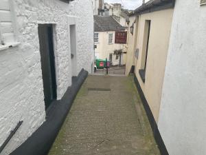 eine Gasse zwischen zwei weißen Gebäuden mit einer grünen Tür in der Unterkunft Sea-la-vie in Ahoghill