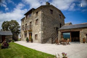 un gran edificio de piedra con patio en Apartamentos Rurales El Foro, en Andés