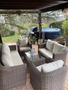 a patio with wicker chairs and couches and a grill at Chambre avec terrasse in LʼIsle-Jourdain +18 photos