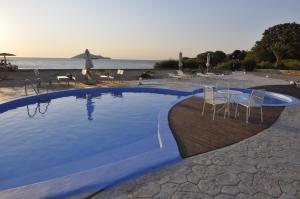 una piscina con sillas y una mesa y la playa en Tony's Beach, en Vromolithos