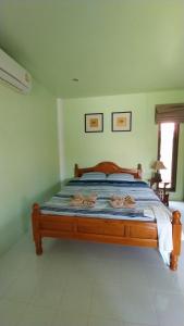a bedroom with a bed with a wooden frame at LANTA LUCKY HOUSE in Ko Lanta