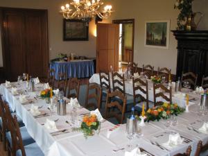 ein Esszimmer mit Tischen und Stühlen mit Blumen in der Unterkunft Gästehaus Villa Wolff in Bomlitz