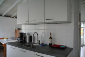 a kitchen with a sink and a bottle of wine at Rekerlanden 90 in Schoorldam