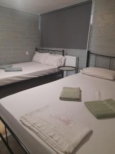 two beds in a room with towels on them at Antonioy Apartment Kalampaka in Kalabaka