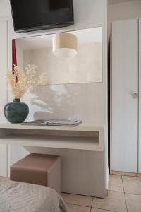 a bedroom with a table with a vase on it at Hotel San Marco in Milano Marittima