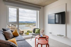a living room with a couch and a large window at Casa Cima in Ushuaia