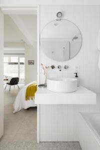 a white bathroom with a sink and a mirror at Casa Cima in Ushuaia
