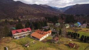 eine Luftaufnahme eines Hauses mit einem roten Dach in der Unterkunft Pensiunea Florina in Poiana Mărului