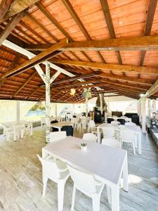 ein Esszimmer mit weißen Tischen und weißen Stühlen in der Unterkunft Pensiunea Florina in Poiana Mărului