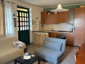 salon z kanapą i krzesłem oraz kuchnia w obiekcie Mini Villetta San Giorgio w mieście San Giorgio