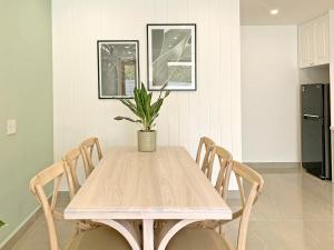 a dining room table with chairs and a potted plant at LALALA - Ngôi nhà nhỏ xinh tại Đà Lạt in Da Lat