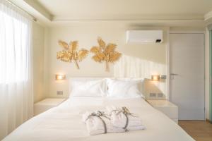a bedroom with a white bed with towels on it at Rooms Le Rive 23 in Costa Volpino