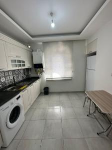 una cocina con lavadora y mesa en Central Suites Trabzon, en Trabzon