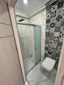 Un baño con inodoro y ducha de cristal. en Central Suites Trabzon, en Trabzon