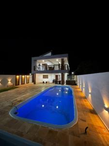una piscina frente a una casa por la noche en Dinart's House, en Lucena